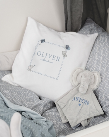 Vit kudde med elefantmotiv samt namn och datum