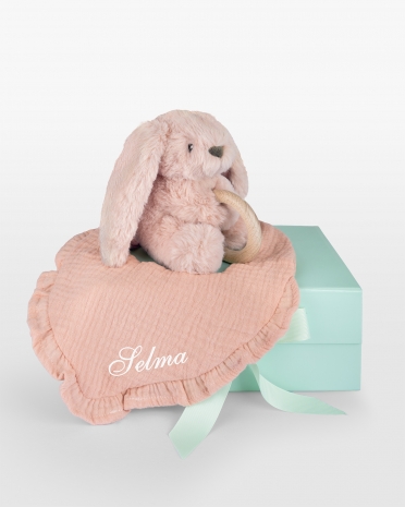 presentset i rosa med dregellapp med namn och en gosedjurskanin med bitring i trä