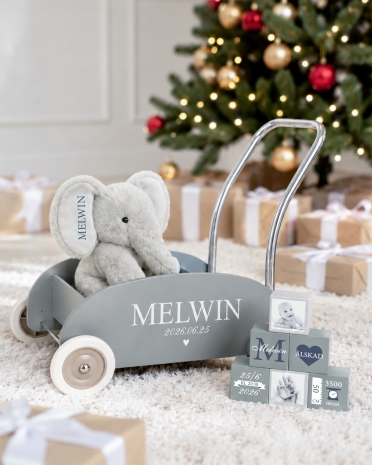 Presentset till barn innehållande en blå lära-gå-vagn med namn och datum, gosedjurselefant med namn och klossar med namn, datum
