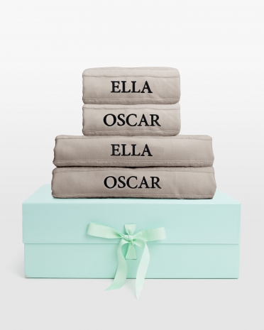 Sand handdukset med duschhanddukar och svart namnbrodyr, perfekt för modern komfort och subtil elegans.