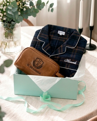 Personligt presentset till pappa innehållande en mörkblå pyjamas och cognacfärgad lädernecessär med brodyr
