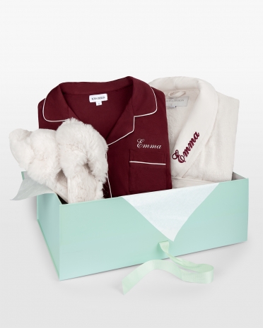 Presentset till henne innehållande en vinröd pyjamas och cremefärgad badrock med namn, samt fluffiga cremefärgade tofflor