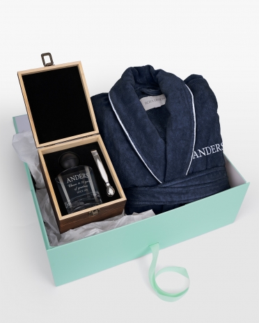 Navy badrock med vit namnbrodyr och whiskyglas med graverat namn, för stilfull komfort och personlig lyx.