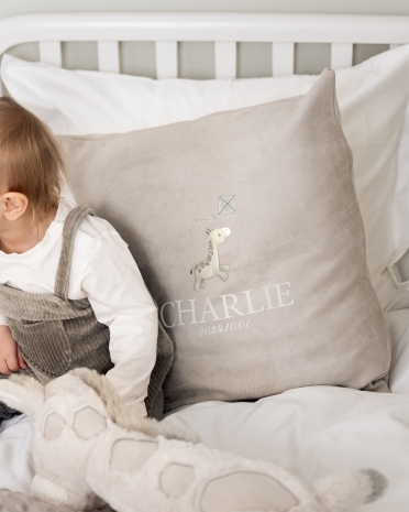 Grått kuddfodral i sammet med namn och giraffmotiv