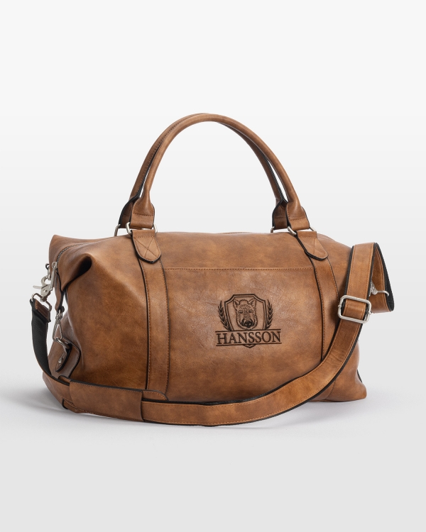 Kraftfull weekendbag i cognac med broderat namn och vildsvinsmotiv, idealisk för stil och funktion.