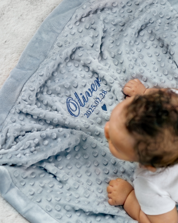 Blå gosig filt med broderat namn och födelsedatum