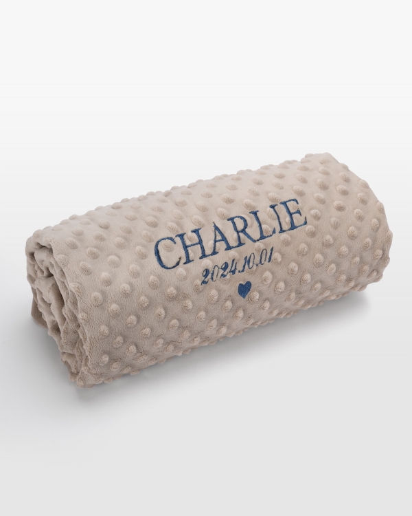 Sandfärgad babyfilt med namn i blå brodyr