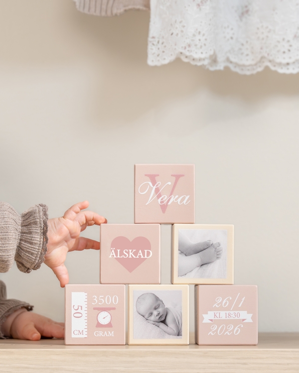 Rosa träklossar med barnets namn och födelseuppgifter