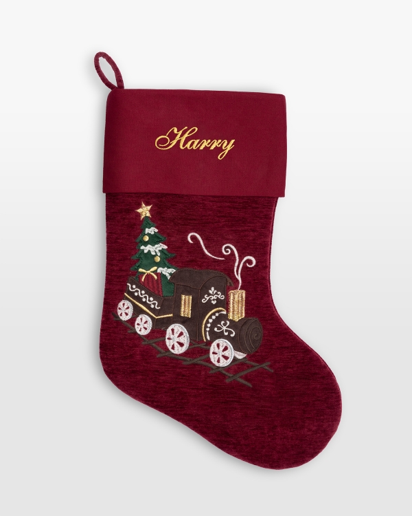 Röd julstrumpa med broderat namn och ett tågmotiv