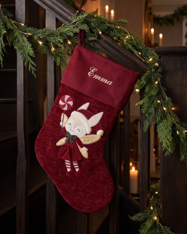 Röd julstrumpa med gulligt motiv i form av en älva, broderas med namn