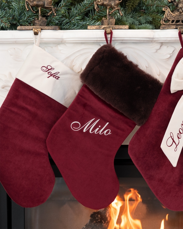 Röd julstrumpa med brun fuskpäls och namn