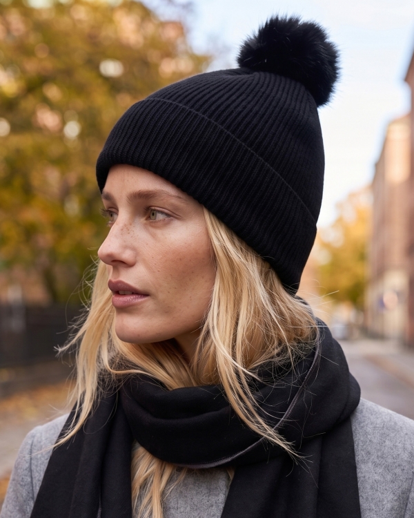 Stickad svart mössa med tofs