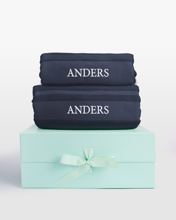 Navy handdukset med duschhandduk och vit namnbrodyr, perfekt för stilfull komfort och personlig elegans.