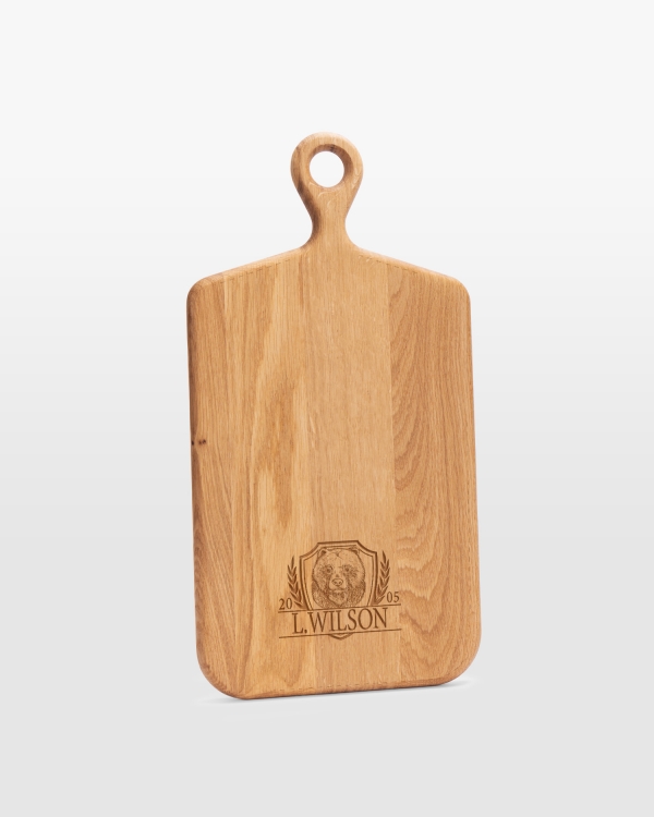 Serveringsbräda graverad med namn och ett jaktmotiv av en björn