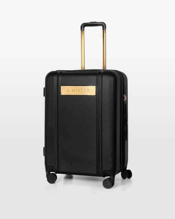 Svart resväska med namn och guldiga detaljer