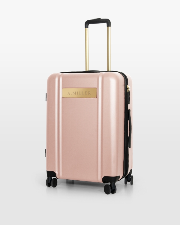 Rosa resväska med namn och guldiga detaljer