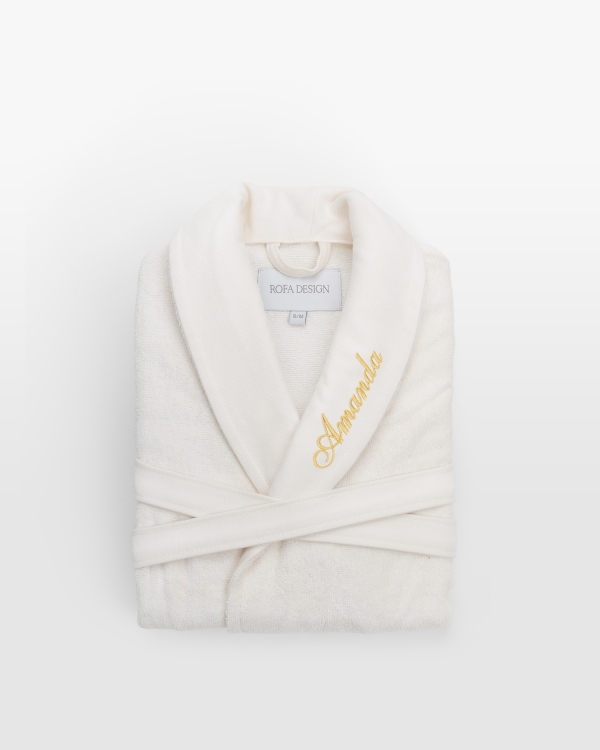 Lyxig creme barnbadrock med personlig guldbrodyr, en exklusiv touch för barns mysiga stunder.
