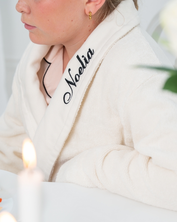 Lyxig creme morgonrock med svart broderat namn för barn
