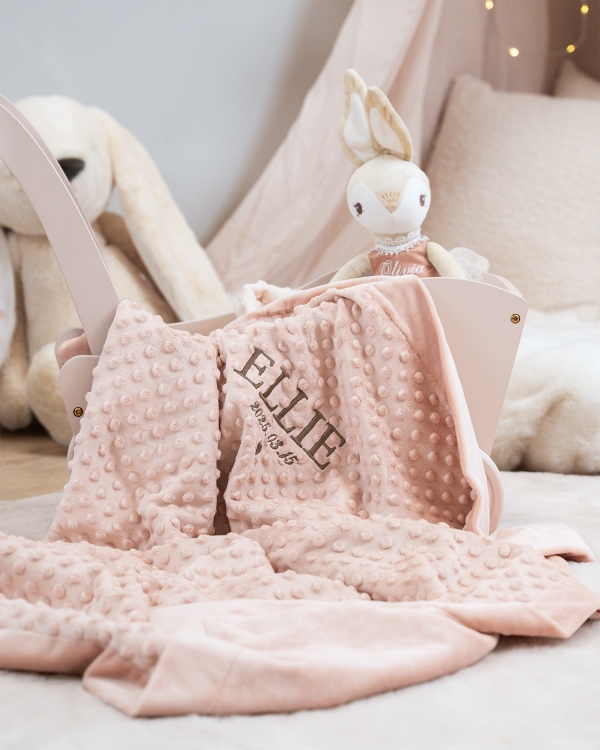 Mysig rosa filt med broderat namn och datum till barnrummet