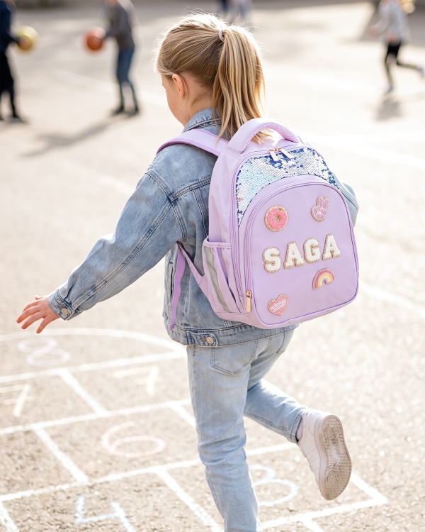 Lila ryggsäck med paljetter och tygmärken