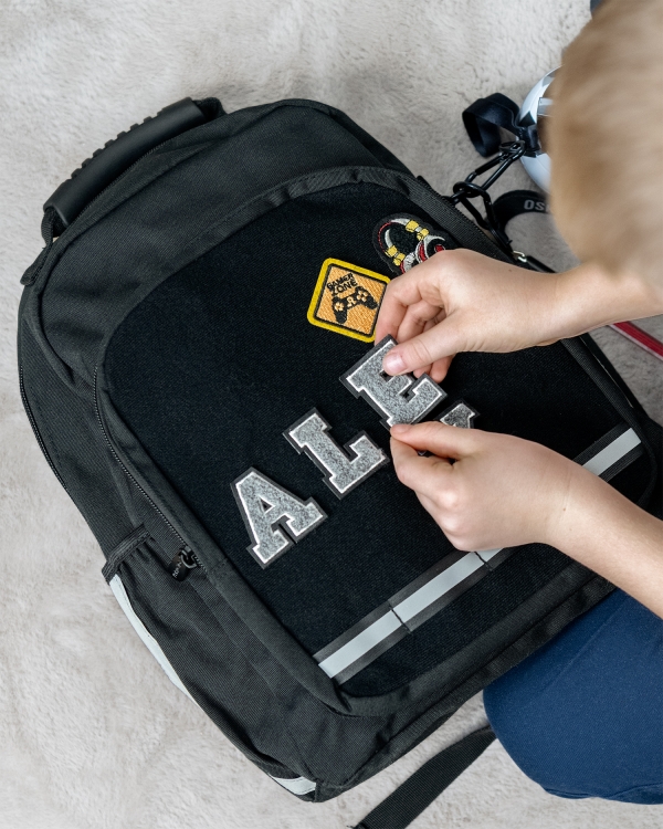 svart skolryggsäck med tygmärken