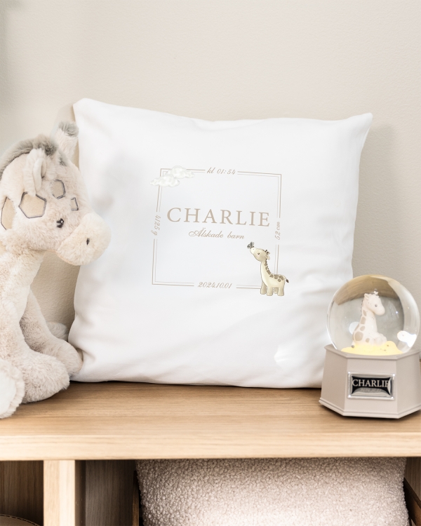 Vitt kuddfodral med tryckt giraffmotiv och namn och datum