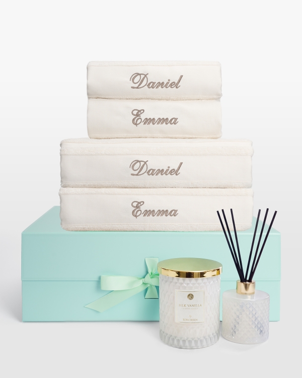 cremefärgade handdukar broderade med namn, i ett presentset med matchande doftljus och doftpinnar